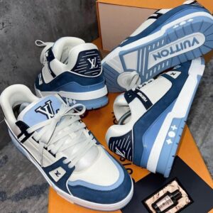 A pair of white and blue Louis Vuitton sneakers on an orange shoe box, showcasing the iconic brand's luxury footwear.