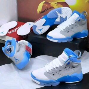 A pair of white and red Air Jordan 9 high-top sneakers displayed on a shoe box, showcasing their sleek design and vibrant color accents.