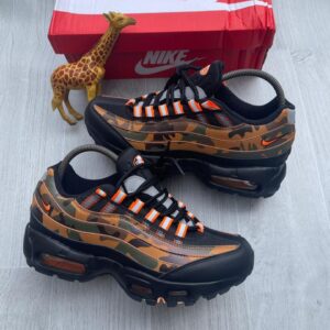Luxury Camo Nike Air Max 270 React sneakers with black and orange accents, displayed with a giraffe figurine and red Nike box, showcasing high-class style for the elites in Nigeria.