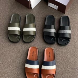 A collection of luxury Pedro brand slide sandals in various colors, including green, black, and brown, displayed on a carpeted floor with shoe boxes and a bottle in the background.