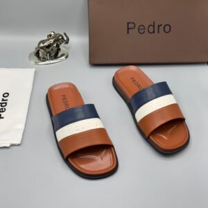 Luxury Pedro slides with brown, navy blue, and white straps, presented with a brown box and silver elephant figurine on a grey background | Levonteluxe