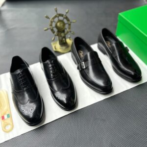 A pair of luxurious black leather oxford shoes with brogue detailing, accompanied by a shoe tree and presented on a premium white cloth, evoking a sense of high-end style and refinement.