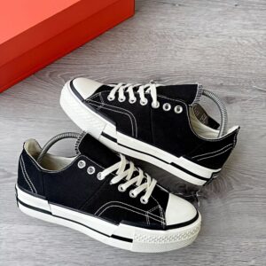 A pair of luxurious black sneakers with white laces and rubber soles, exuding high-class style and comfort.