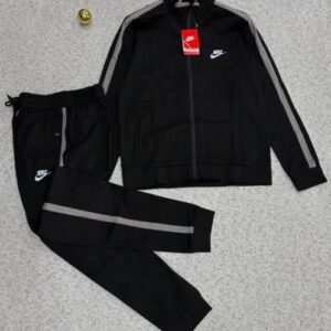 A luxurious black tracksuit with grey stripes and Nike logo, laid out on a grey surface, exuding high-end quality and style.