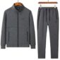 A luxurious tracksuit consisting of a gray zip-up jacket and matching gray sweatpants, both adorned with the Nike logo, hanging on wooden hangers against a white background.